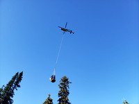 a helicopter shuttles firewood to Elizabeth Parker Hut