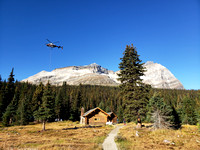 a helicopter shuttles firewood to Elizabeth Parker Hut