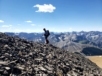 Clayton re-ascending Outlaw Peak, with a sea of peaks behind